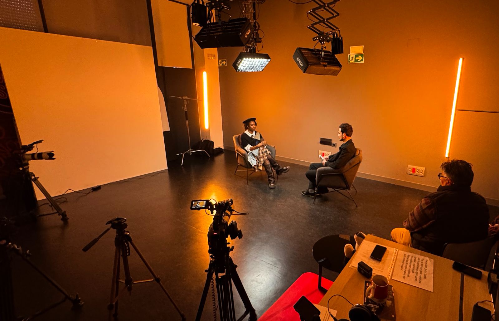 Plató de programa de televisión y podcast con entrevista a dos personas