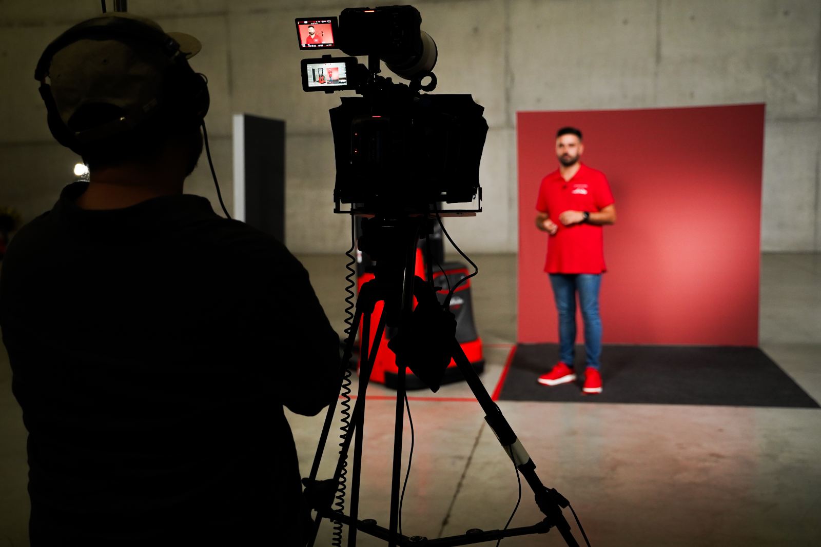 Rodaje con un experto técnico delante de la cámara sobre fondo rojo de marca